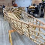Wooden boat hull framework under construction in a workshop
