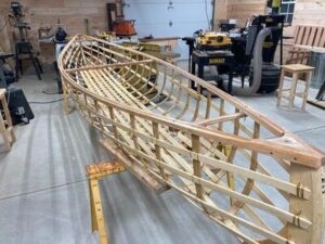 Wooden boat hull framework under construction in a workshop